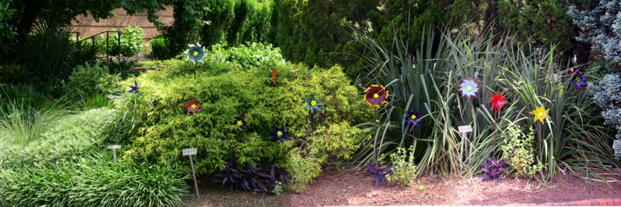 [Three photos stitched together displaying colorful metal art flowers posted in the garden.]